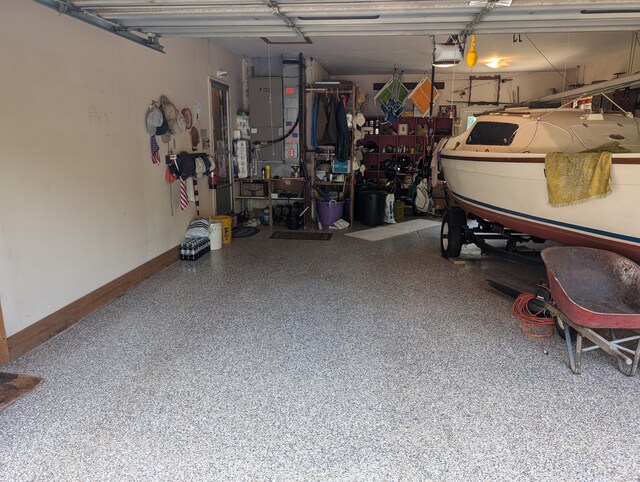 3641 Green Lake Rd, West Bloomfield, MI 48324 - garage with a garage door opener, baseboards, a workshop area, and heating unit
