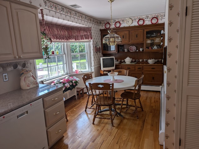 dining area with light hardwood / wood-style flooring and a baseboard radiator