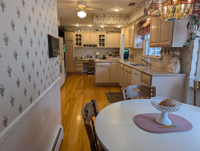 kitchen featuring dishwasher, ceiling fan with notable chandelier, sink, light wood-type flooring, and decorative light fixtures