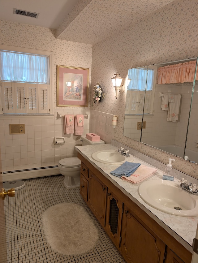 full bathroom featuring tile patterned flooring, plenty of natural light, tile walls, and a baseboard heating unit