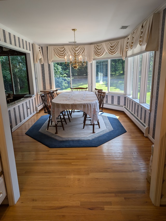 dining space with baseboard heating, a chandelier, a healthy amount of sunlight, and light hardwood / wood-style floors