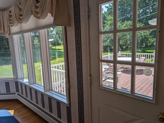 3641 Green Lake Rd, West Bloomfield, MI 48324 - doorway with a baseboard heating unit, plenty of natural light, wood finished floors, and view of scattered trees