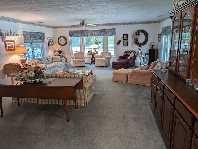 living room featuring ceiling fan, dark carpet, and a textured ceiling