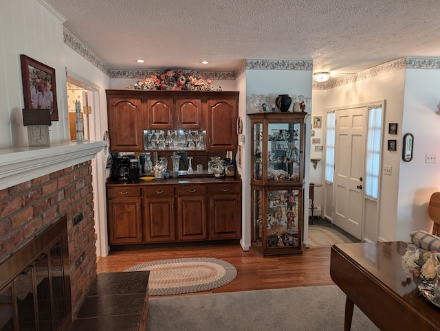 kitchen featuring a fireplace, wood-type flooring, and a textured ceiling