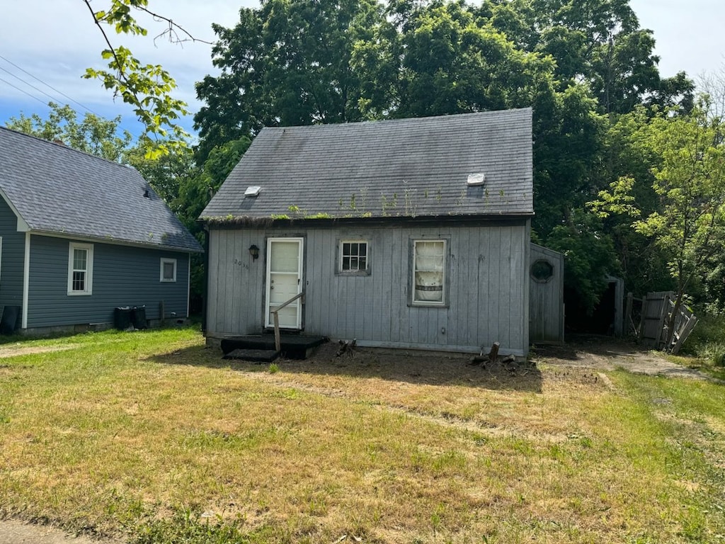 rear view of property with a lawn