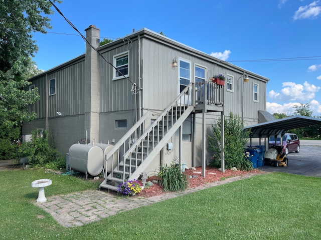 11424 W Corunna Rd, Lennon, MI 48449 - back of property with a lawn, stairs, a detached carport, oil tank, and a chimney