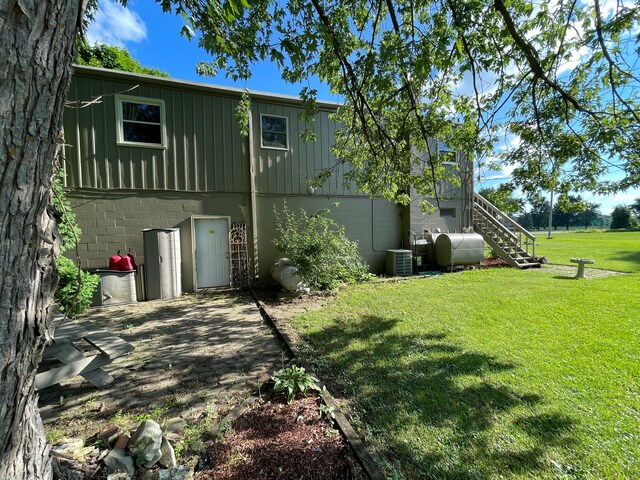 11424 W Corunna Rd, Lennon, MI 48449 - back of property featuring cooling unit, stairs, a lawn, oil tank, and concrete block siding