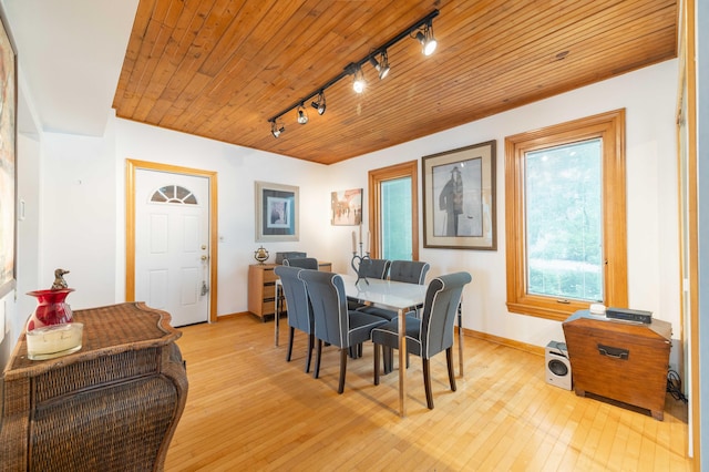 dining space featuring light hardwood / wood-style floors, track lighting, and wood ceiling