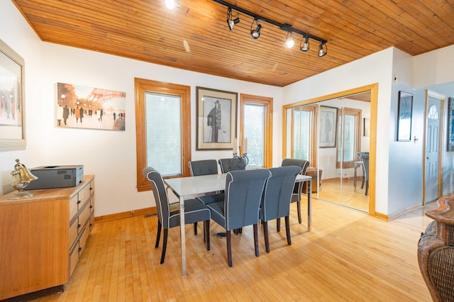 dining area featuring light wood-type flooring, rail lighting, and wood ceiling