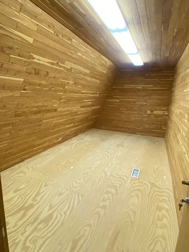 bonus room featuring wood walls and wood ceiling