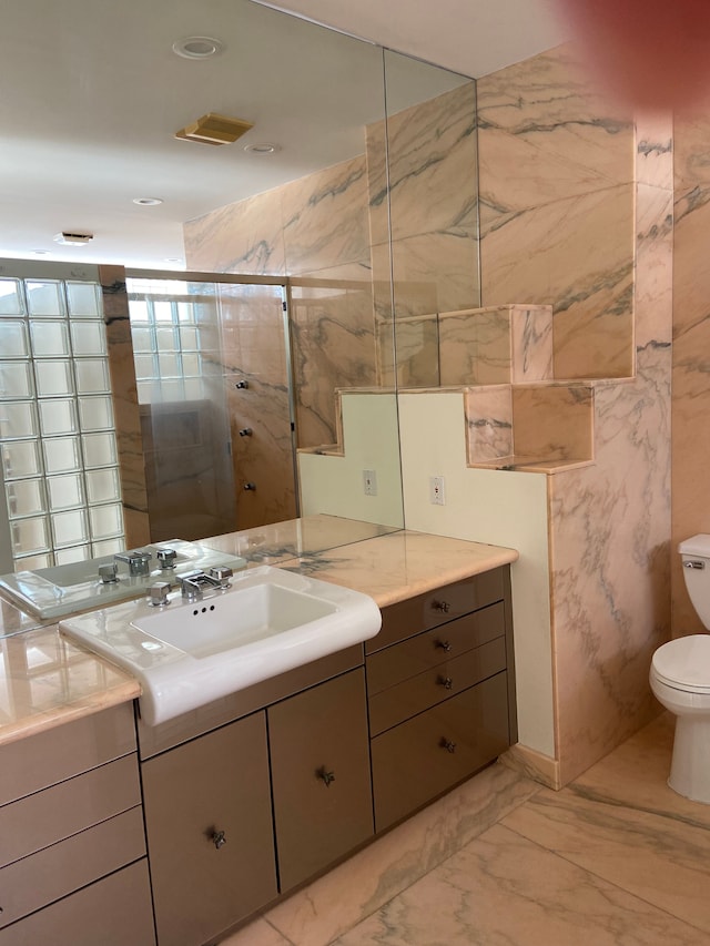 bathroom with vanity, toilet, and a shower with shower door