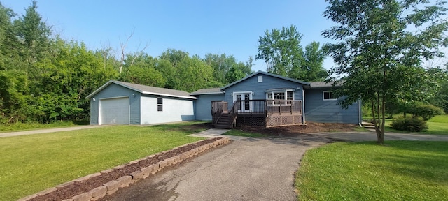 single story home featuring a wooden deck, a front lawn, an outdoor structure, and a garage