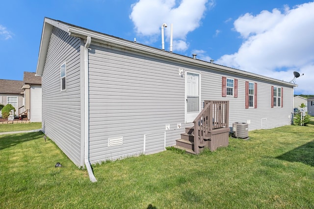 back of house featuring a yard and central AC unit