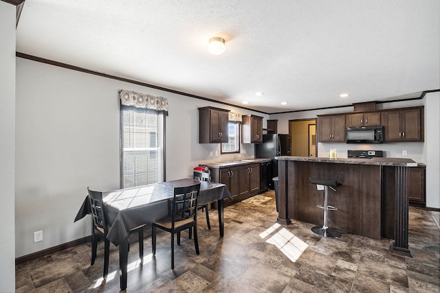 kitchen with dark brown cabinetry, crown molding, sink, black appliances, and a center island