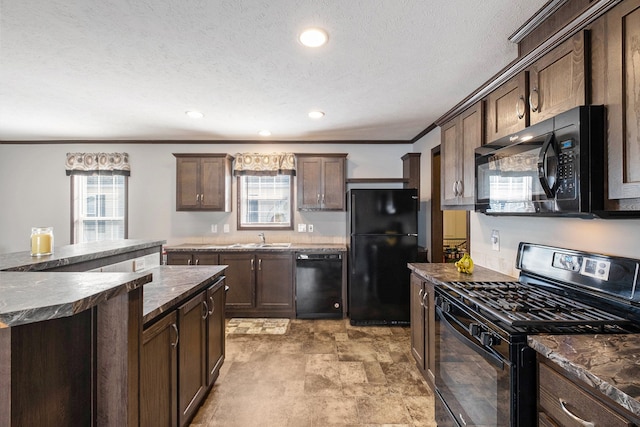 kitchen featuring black appliances, dark brown cabinets, crown molding, and a wealth of natural light