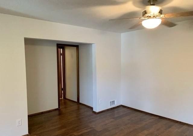 unfurnished room with ceiling fan and dark wood-type flooring