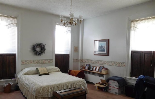 carpeted bedroom featuring a textured ceiling, radiator, and an inviting chandelier