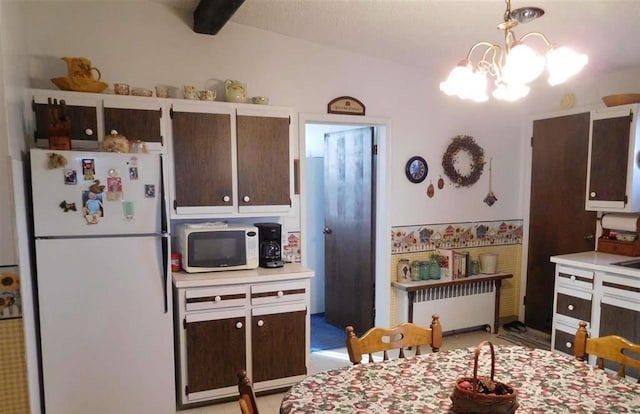 kitchen featuring radiator, dark brown cabinets, white appliances, a notable chandelier, and hanging light fixtures