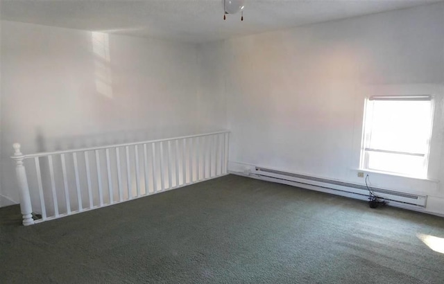 spare room featuring dark carpet and a baseboard heating unit