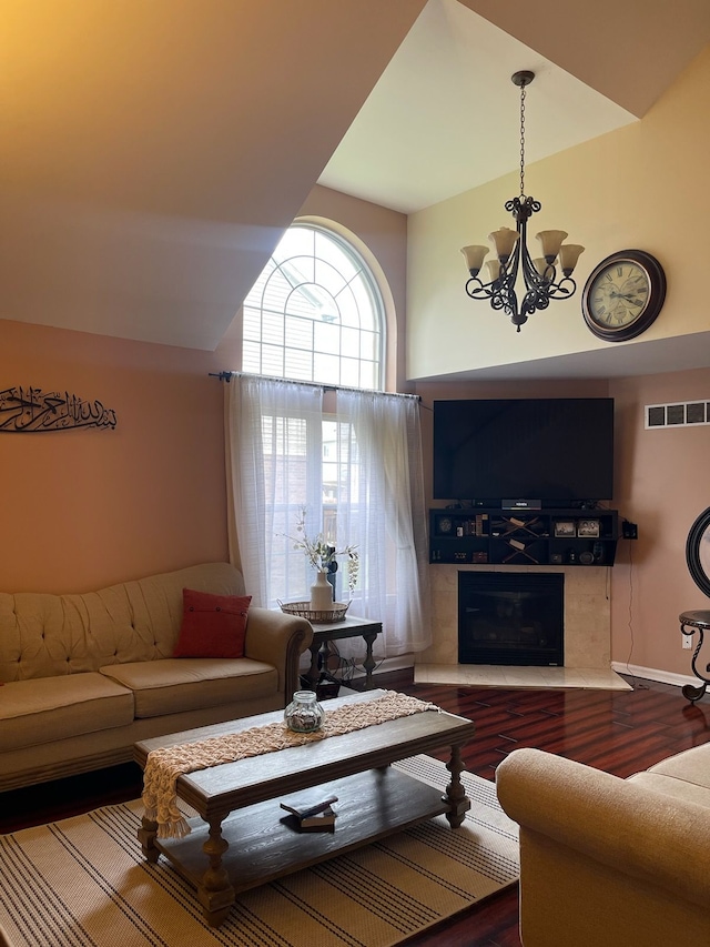 living room with a high end fireplace, wood-type flooring, and an inviting chandelier