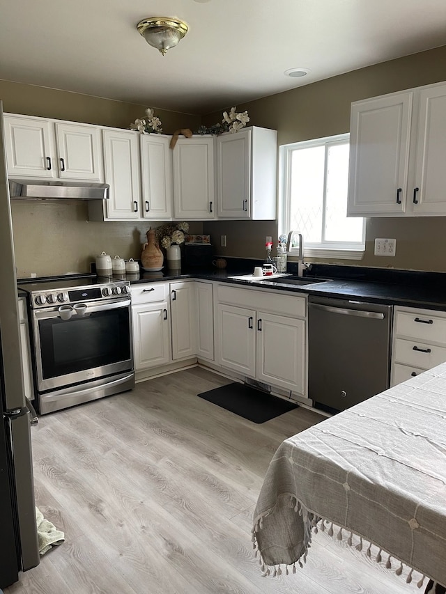 kitchen with light wood-type flooring, stainless steel appliances, white cabinetry, and sink