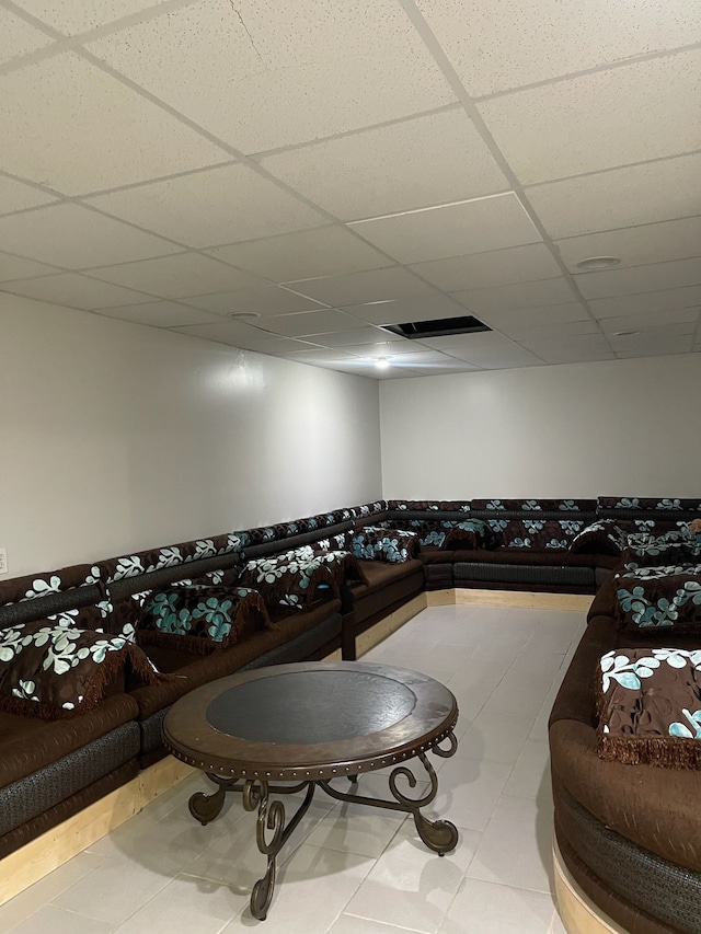 living room with tile patterned flooring and a paneled ceiling