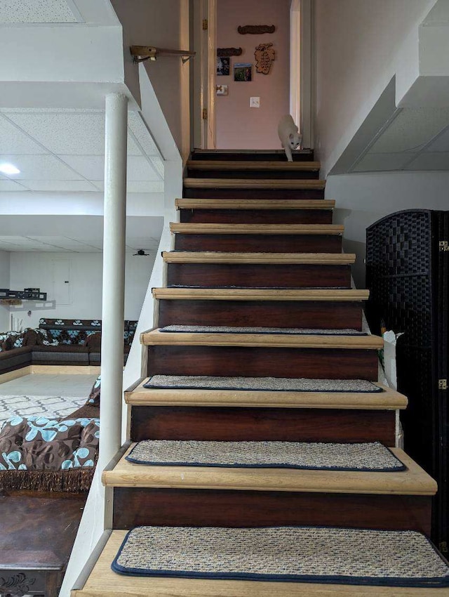 staircase with a paneled ceiling