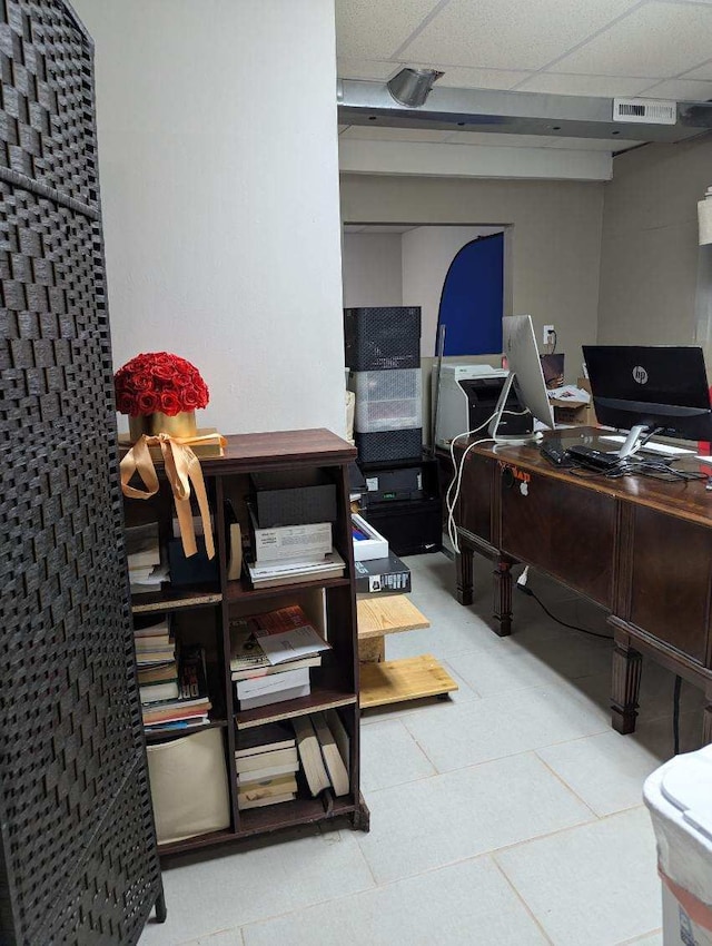 office space with tile patterned floors and a drop ceiling