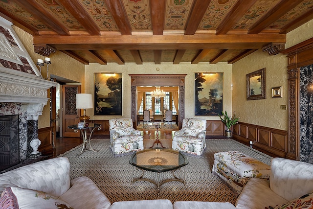 living room with hardwood / wood-style floors, beam ceiling, a fireplace, and an inviting chandelier