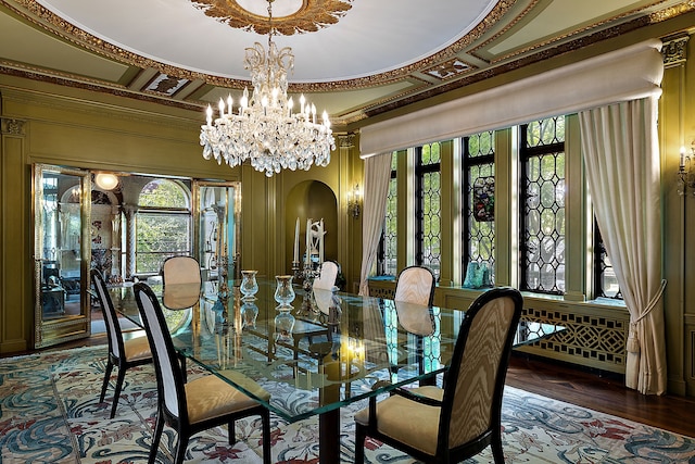 dining room featuring wood-type flooring, ornamental molding, a wealth of natural light, and a chandelier