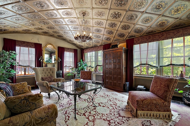 sitting room with a healthy amount of sunlight, lofted ceiling, and an inviting chandelier