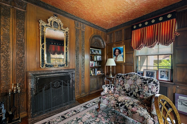 sitting room with hardwood / wood-style floors, a textured ceiling, and wooden walls