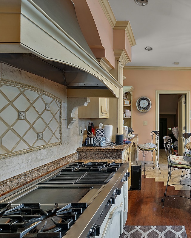 kitchen with backsplash, premium range hood, stainless steel gas cooktop, crown molding, and dark wood-type flooring