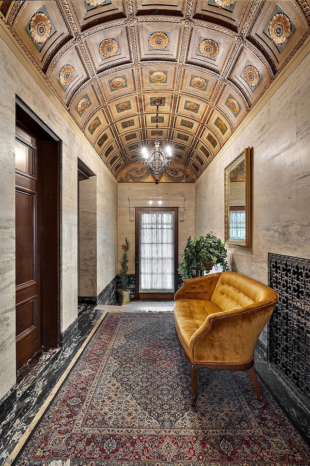 hall with crown molding, lofted ceiling, and an inviting chandelier