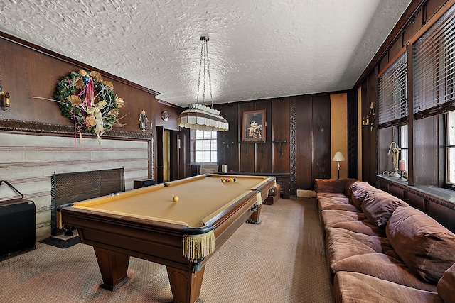 playroom featuring light carpet, a textured ceiling, wooden walls, and billiards