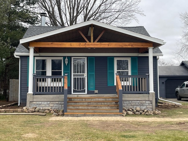 bungalow with an outbuilding, covered porch, and a garage