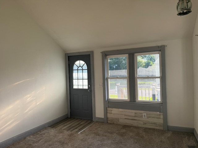 carpeted entryway with lofted ceiling