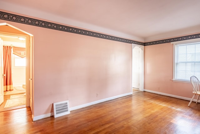 spare room with wood-type flooring and a wealth of natural light