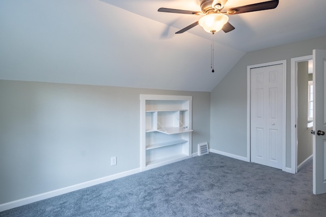 additional living space featuring carpet, vaulted ceiling, ceiling fan, and built in features