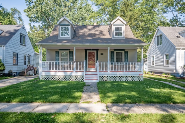 new england style home featuring covered porch and a front yard