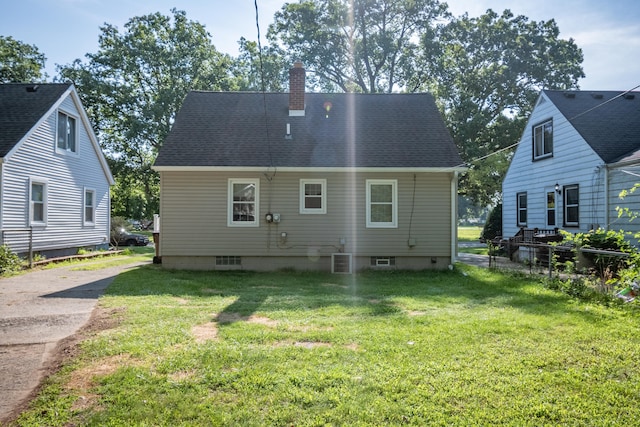 back of property with a yard and central AC