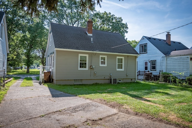 back of house with central AC and a yard