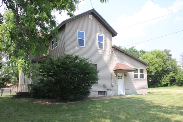 rear view of property featuring a yard