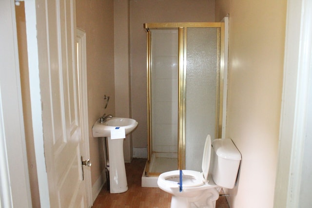 bathroom featuring hardwood / wood-style floors, sink, toilet, and walk in shower