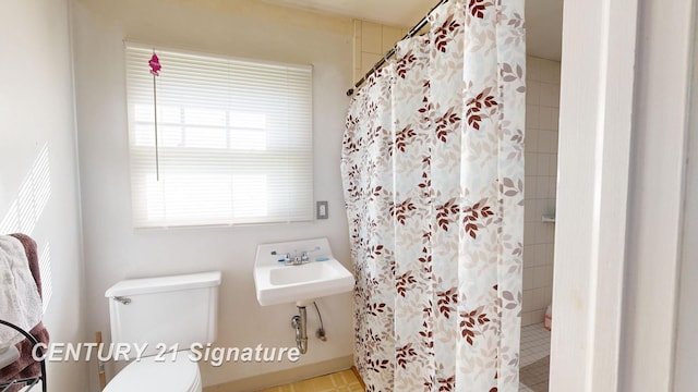 bathroom with a shower with curtain, toilet, and sink