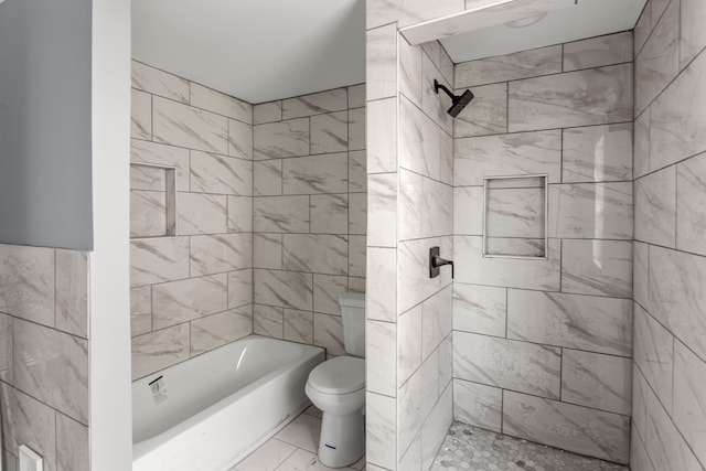 bathroom with toilet, tile walls, and tiled shower / bath