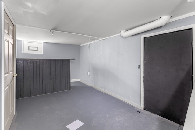 basement featuring wood walls