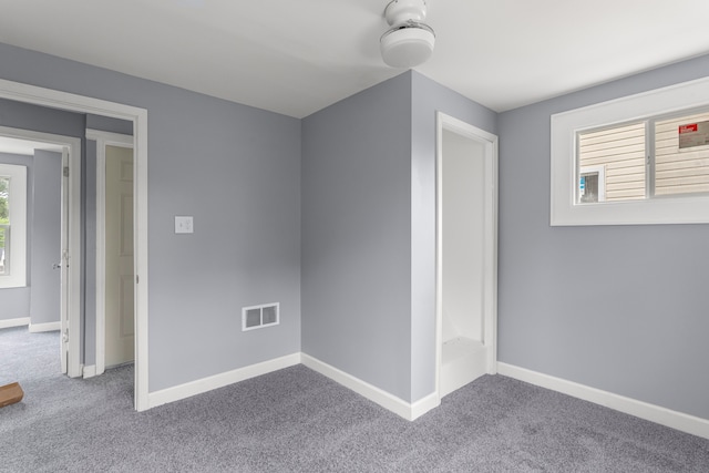 unfurnished bedroom featuring carpet and multiple windows