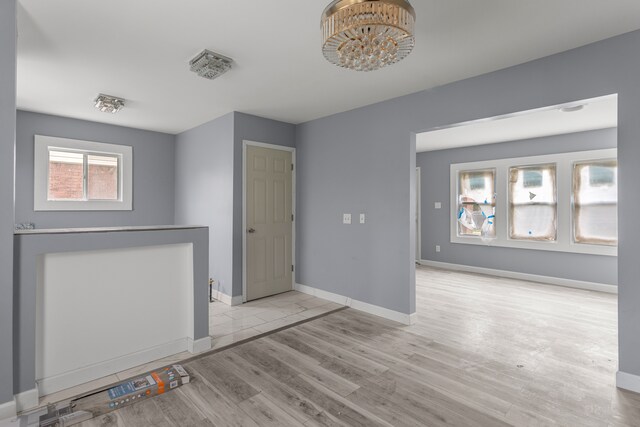 13437 E State Fair St, Detroit, MI 48205 - empty room featuring wood finished floors, baseboards, and a chandelier