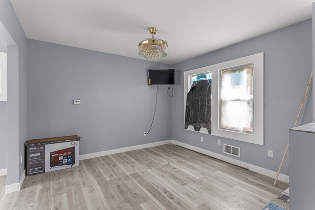 13437 E State Fair St, Detroit, MI 48205 - unfurnished living room with a chandelier, wood finished floors, and baseboards